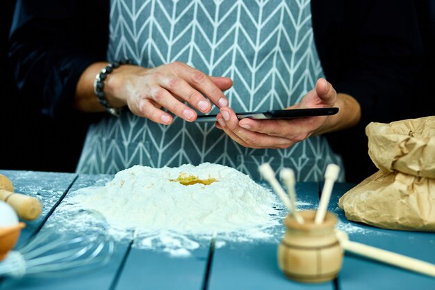 Man met behulp van elektronische tablet-pc in de keuken om te bakken.