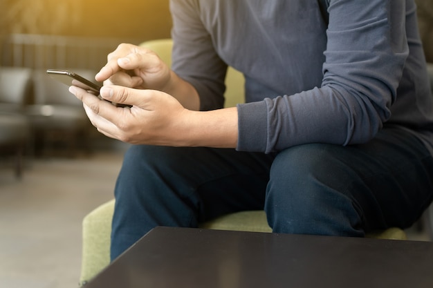 man met behulp van slimme telefoon op en het lezen van de boodschap in de coffeeshop