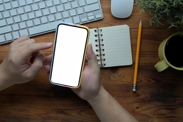 Man met behulp van slimme telefoon op zijn creatieve werkruimte