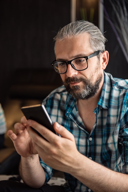 Man met behulp van slimme telefoon thuis