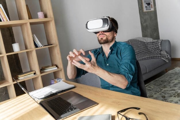 Man met behulp van virtual reality headset thuis met laptop