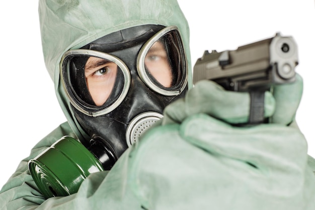 Man met beschermend masker en beschermende kleding die een pistoolportret houdt dat over witte studioachtergrond wordt geïsoleerd