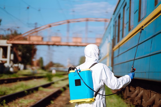 Man met beschermend pak die een trein ontsmet