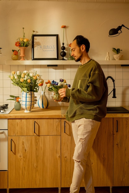 Man met bloemen in de keuken