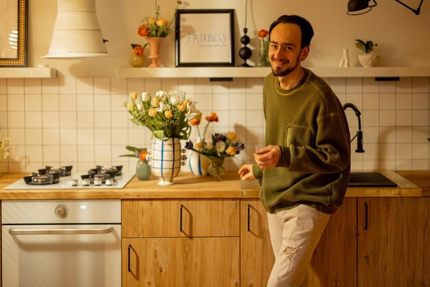 Man met bloemen in de keuken