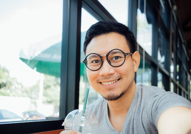 Man met bril drinkt koffie in het café