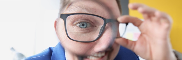 Man met bril met vergrootglas voor zijn oog close-up financiële inspectie