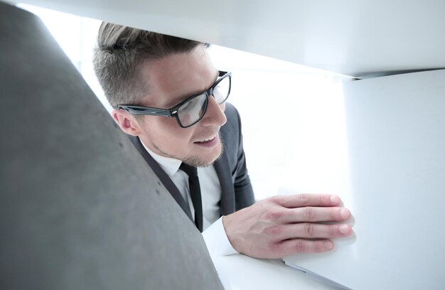 Man met bril op kantoor op zoek naar documenten