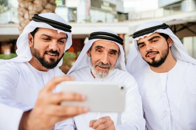 Foto man met broer en grootvader draagt schotel dash nemen selfie van telefoon buiten