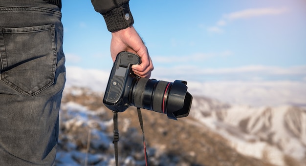 Man met camera in besneeuwde berg in de winter