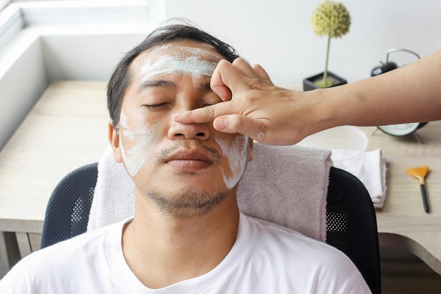 Man met cosmetisch masker in spa salon