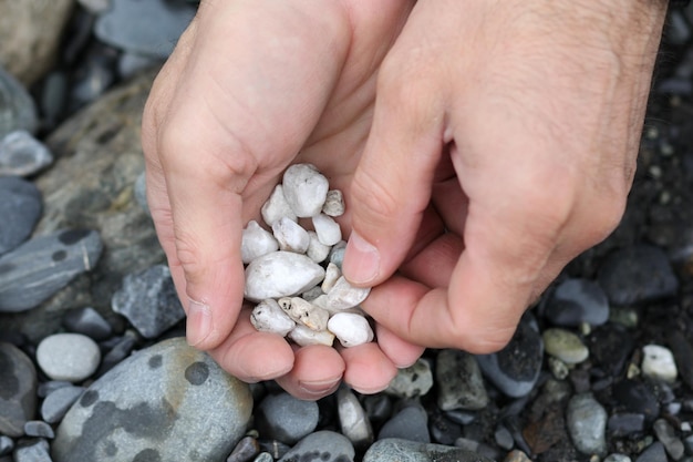 Man met de hand stenen oprapen van het rivierstrand