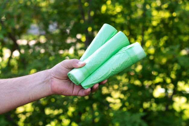 Man met eco plastic vuilniszakken bio op rollen buitenshuis