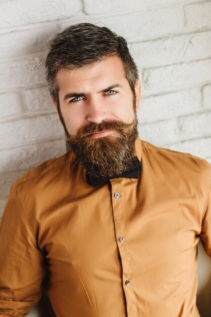 Man met een baard close-up op een achtergrond van witte bakstenen muur