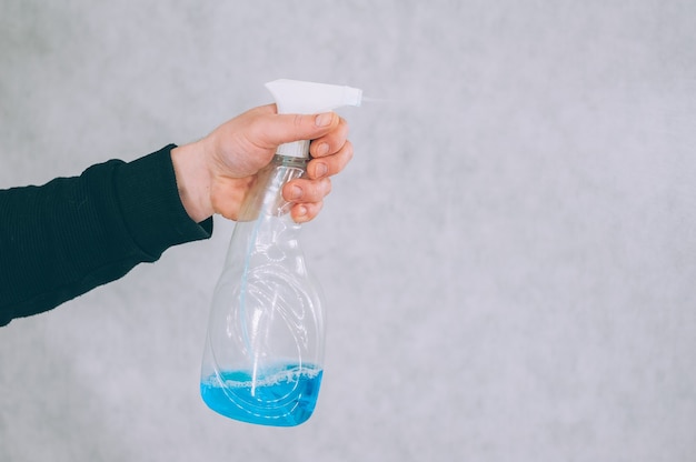 Man met een blauw antisepticum in zijn hand