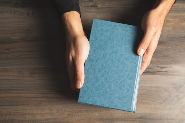 Man met een boek aan tafel. uitzicht van boven