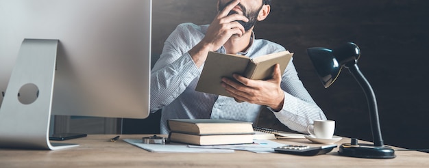 Man met een boek op kantoor