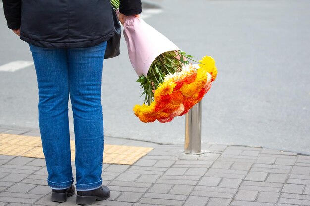 Man met een boeket heldere bloemen op een straat in de stad