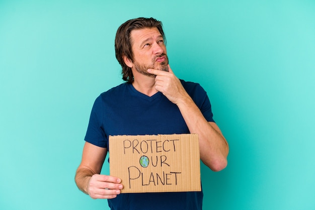 man met een bordje beschermen onze planeet geïsoleerd op blauw