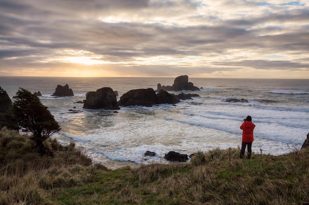 Man met een camera kijkt naar de kust van de Stille Oceaan