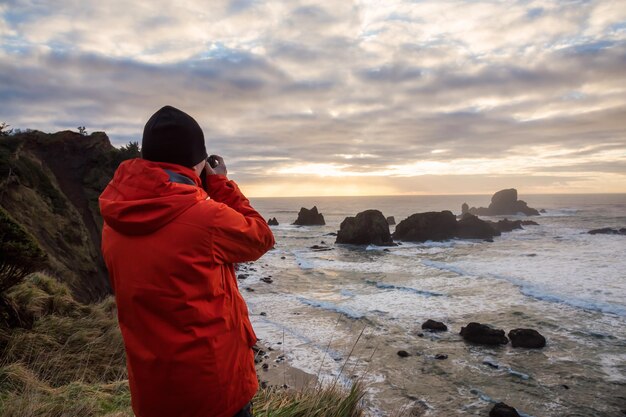 Man met een camera kijkt naar de kust van de Stille Oceaan