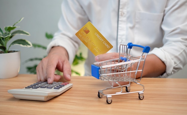 Man met een creditcard en een rekenmachine in de hand Shopping concept Cashless betaling concept