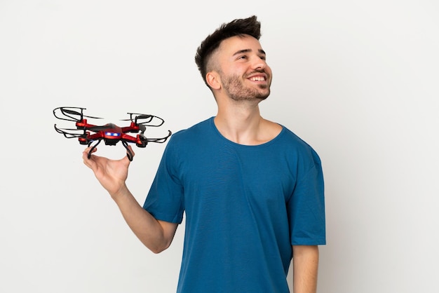Man met een drone geïsoleerd op een witte achtergrond die een idee denkt terwijl hij omhoog kijkt