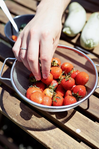 Foto man met een emmer met aardbeien