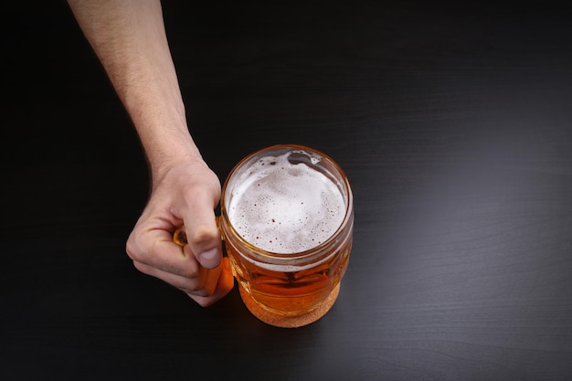 Man met een glas bier op donkere achtergrond