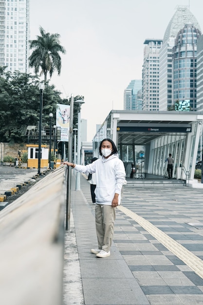 Foto man met een hoodie die poseert in de straat van de stad