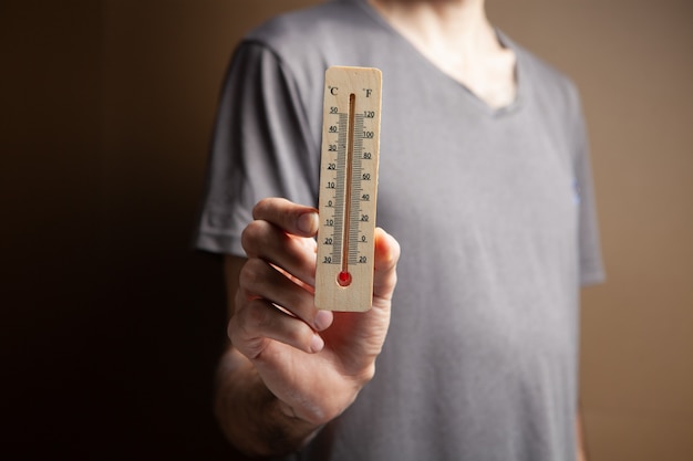 Man met een huisthermometer. luchttemperatuur