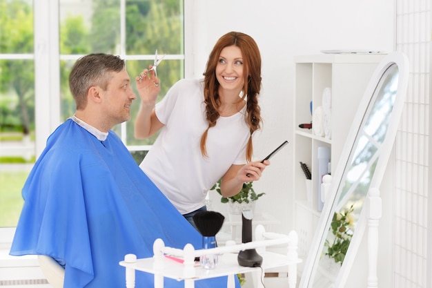 Man met een kapsel van vrouwelijke kapper bij salon