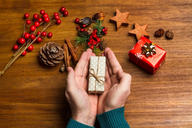 Man met een kerstcadeau op een houten tafel in een bovenaanzicht