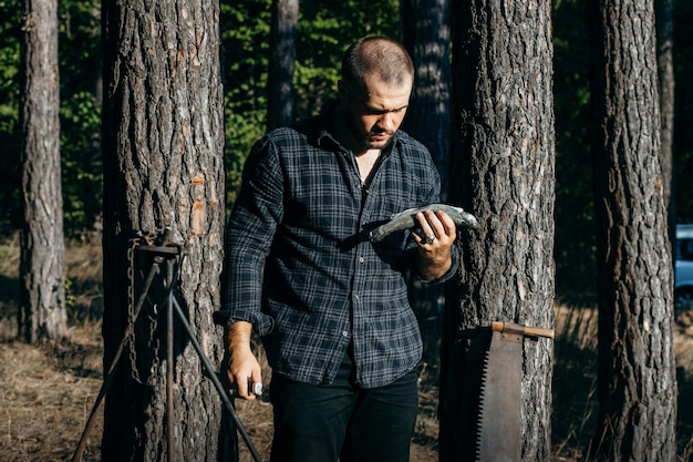 Man met een mes snijdt vis in het bos