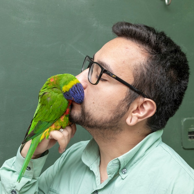 Man met een papegaai Trichoglossus moluccanus