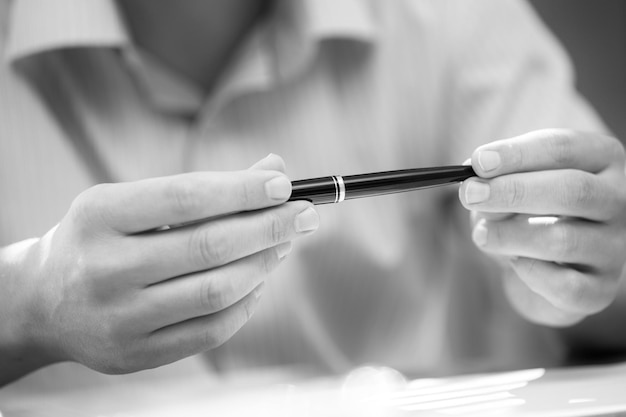 Man met een pen in handen bij onderhandeling