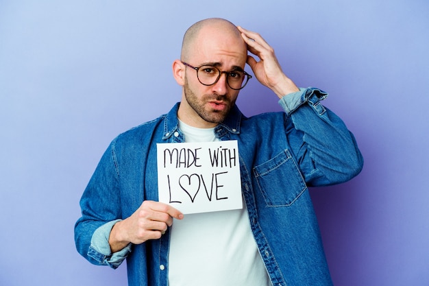 man met een plakkaat gemaakt met liefde geïsoleerd op paars