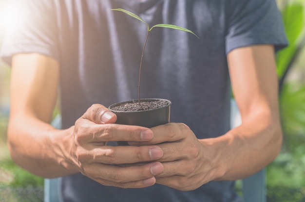 Man met een plantpot. Concept liefde voor planten.