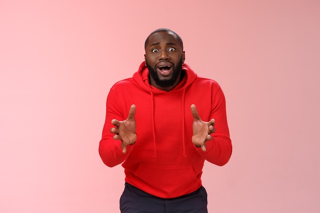 Man met een rood sweatshirt over roze