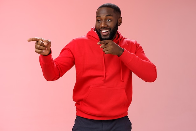 Man met een rood sweatshirt over roze