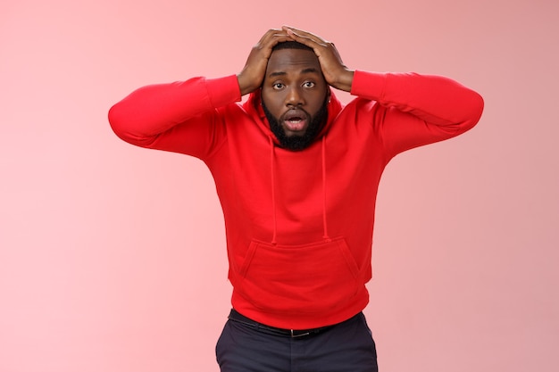 Man met een rood sweatshirt over roze