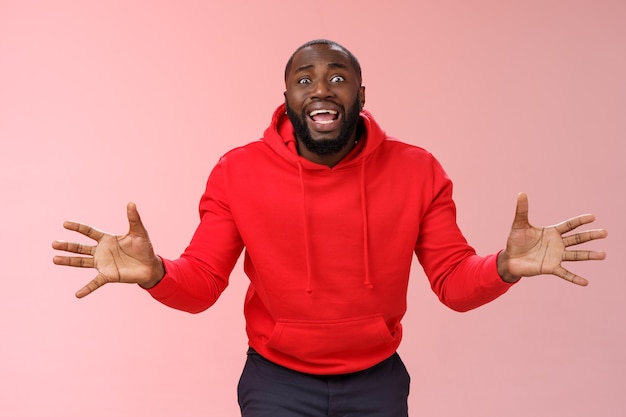 Man met een rood sweatshirt over roze