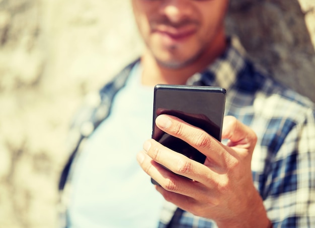 man met een smartphone die buiten sms't