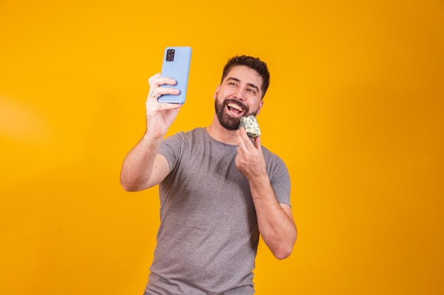 Man met een stuk kaas in de ene hand en met de andere haar mobiele telefoon