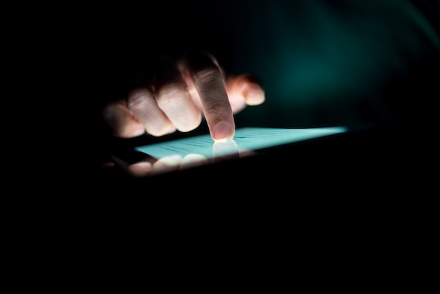 Man met een tablet in het donker