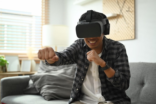 Man met een virtual reality-headset die een simulatie-boksspel speelt in de woonkamer