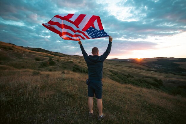 Foto man met een wuivende amerikaanse vlag van de vs