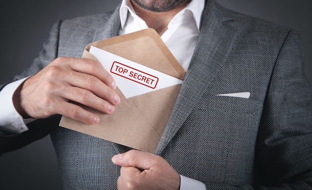 Foto man met envelop met topgeheime stempel.