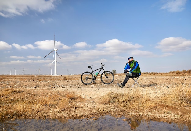 Man met fiets bij windmolenpark