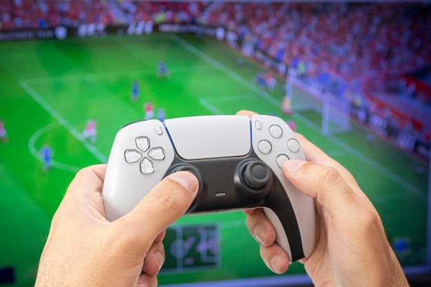 Man met gamecontroller die voetbalspel speelt